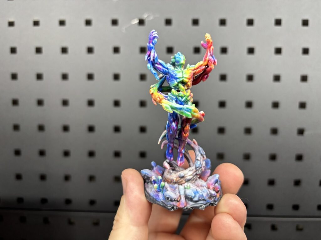 Full-colour 3D printed fantasy figure with a rainbow finish on a rocky base