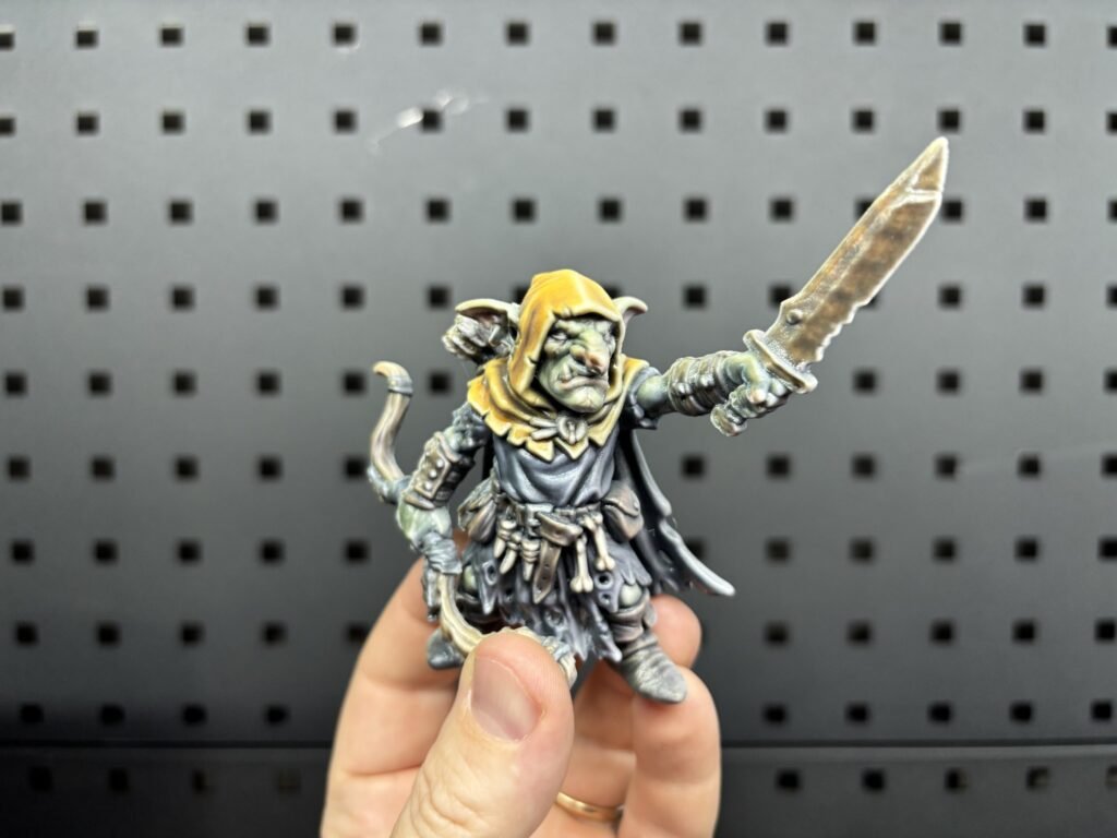 Full-colour 3D printed goblin archer miniature holding a blade