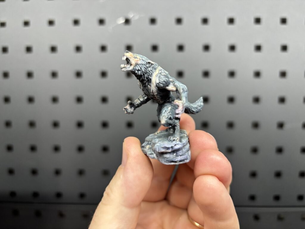 Full-colour 3D printed werewolf miniature on a rocky base