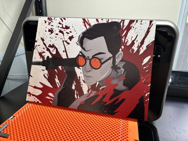 Stylised swordswoman with red splatter UV printed on a wood panel, resting on the printer bed